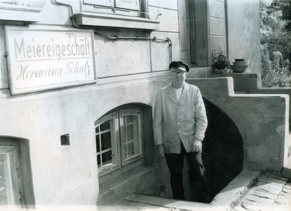 Hermann Schulz vor seinem Meiereigeschäft in Övelgönne 5. Aufgenommen um 1960